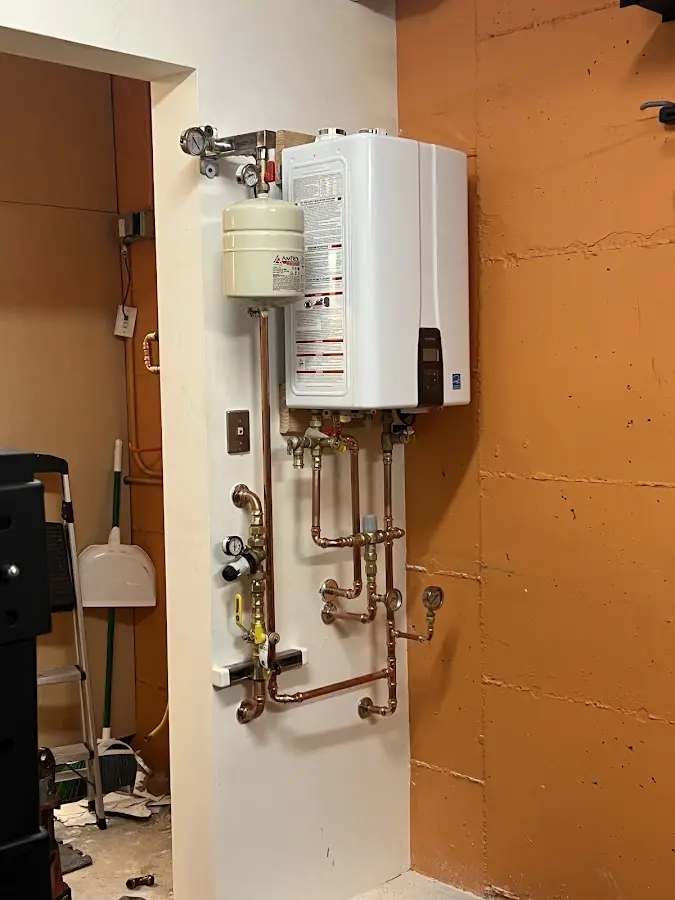 Plumbing technician inspecting water heater connections in East Highland Park